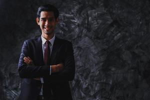 Young leader and businessman portrait on dark background, confidence and happy smart man photo