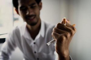World No Tobacco Day in May, stop smoking concept, young man against cigarette photo