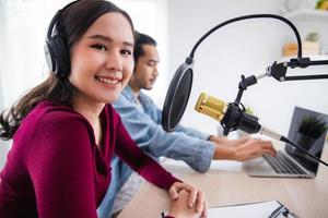 podcaster asiático femenino y masculino haciendo podcast de audio en estudio en casa foto