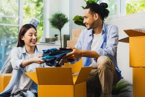 love Asian couple fold cloths into box or take it out to prepare moving new house