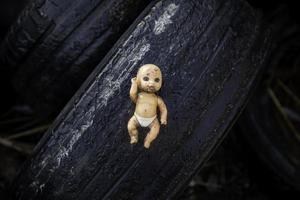 Doll thrown in the trash photo