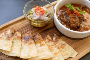 ternera al curry y roti. carne de res, comida tailandesa, colocada sobre la mesa en el restaurante. foto