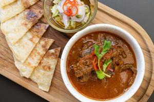 ternera al curry y roti. carne de res, comida tailandesa, colocada sobre la mesa en el restaurante. foto