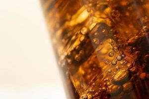 Close up Cola with Ice and bubbles in glass. Ice cubes in cola beverage. photo