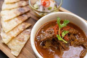 ternera al curry y roti. carne de res, comida tailandesa, colocada sobre la mesa en el restaurante. foto