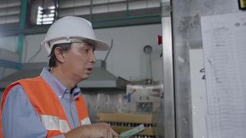 les ingénieurs de machines ou de maintenance inspectent les machines et les stérilisateurs dans les usines ou les industries manufacturières et notent les informations sur tablette. chaudière, autoclave, contrôle d'apparence, test de fonctionnement. video