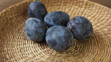 Fresh ripe plums in a basket on a wooden table video