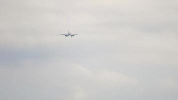 avión de pasajeros acercándose antes de aterrizar contra un cielo gris nublado. concepto de turismo y aviación video