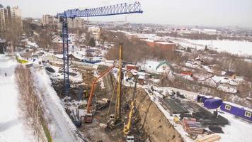 Construction of a multi storey residential building in the city in winter. Aerial View. Crane and building construction site.