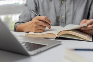 learning online class by using laptop computer and writing notebook at workplace, Education development or knowledge improvement concept. photo