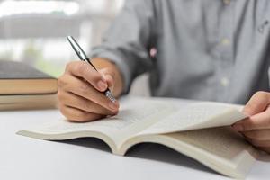 Businessperson reading and writing on book.education studying knowledge development and cognition learning concept. photo