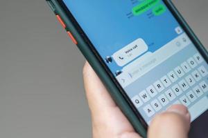 hombre enviando mensajes de texto y sms con el concepto de comunicación de teléfonos inteligentes. escribir con los dedos con el teclado del teléfono celular. foto