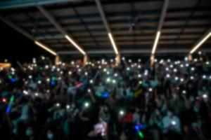 people holding cigarette lighters and mobile smartphones at a concert photo