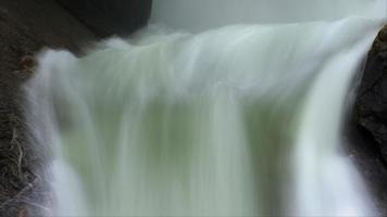 Wispy water falls between huge rocks - Loop video