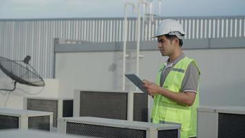 fabriek ingenieurs wandelen en controle de koeling systeem van de fabriek. voor Mens records de staat van de compressor voordat onderhoud volgens onderhoud plan. video