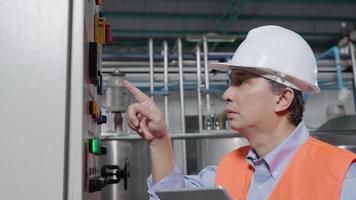 Machine or maintenance engineers inspect machines and power system in factories or manufacturing industries and write down the information on tablet. Boiler, retort, appearance check, function test. video