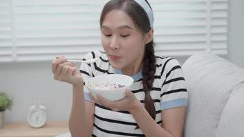 hermosa niña disfruta comer yogur en el desayuno salud en casa. una joven feliz sonríe en la mañana por una buena emoción. comida limpia femenina, dieta, desintoxicación, dieta de yogur. dieta concepto de comida feliz y saludable video