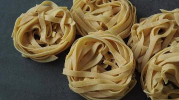 Fresh homemade egg pasta tagliatelle. Raw homemade pasta. Fettuccine pasta raw. Nest of yellow tagliatelle. video