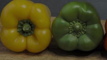 trois poivrons. trois poivrons colorés rouges jaunes et verts d'affilée. video