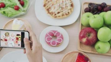 Net idol and take picture for review food. Women use mobile phones to take pictures of food or take live video on social networking applications. Food for lunch looks appetizing.