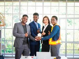 Businesspeople's multiracial colleagues brainstorm with house models and blueprints at the office. Professional construction team discussing the arrangement of service lines at the new building. photo