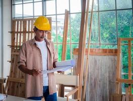 Portrait of a senior carpenter looking at blueprints plans, rechecking and comparing drawing plans. Hobby, Retirement Concept photo