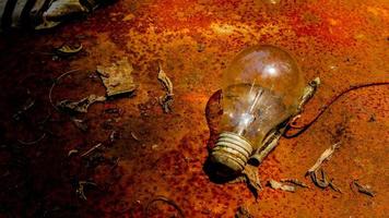 Light bulb on rusty zinc as a background photo