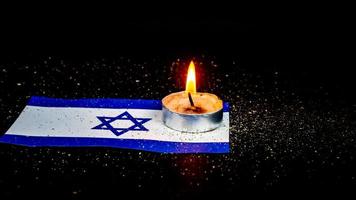 Israeli flag and candles burning above it, Holocaust memory day photo