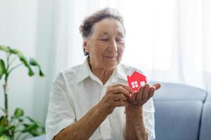 senior woman holds the layout of the house in her hands photo