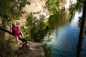 stylish hipster woman with backpack looking at amazing woods and mountains in summer, travel concept, space for text photo