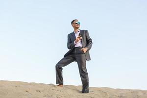 Happy businessman in a suit in the desert photo