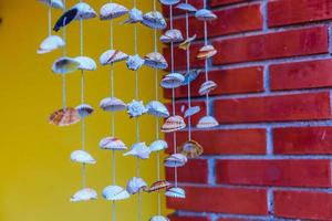 Sea shell hanging with bokeh background. The hanging curtains made of shells are crafts produced by skilled workers. photo