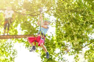 happy little children in a rope park on the wood background photo