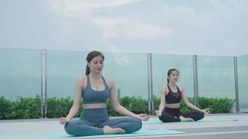 mujer practicando meditar en el balcón. mujer asiática haciendo ejercicios por la mañana. equilibrio, recreación, relajación, calma, buena salud, feliz, relajarse, estilo de vida saludable, reducir el estrés, pacífico