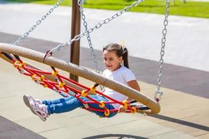 attractive little girl on outdoor playground equipment photo