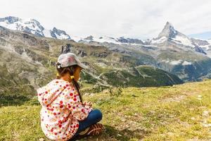 Hiking in the swiss alps with flower field and the Matterhorn peak in the background. photo