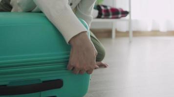 uma mulher abrindo uma mala para colocar roupas para viagem. uma mulher está preparando sua bolsa para uma viagem de férias. conceito de preparação para viagens após a vacinação. video