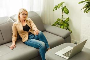 Work during quarantine, a woman at home works on the laptop photo