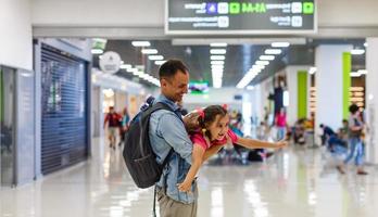Little girl with her father background flight information at airport photo