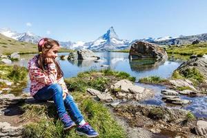 Senderismo en los alpes suizos con campo de flores y el pico Matterhorn al fondo. foto