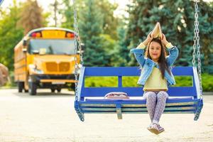 schoolgirl is waiting for a school bus photo