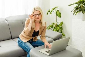 young woman with laptop works at home photo