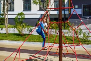 attractive little girl on outdoor playground equipment photo