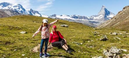 Happy hiker woman and girl at mountains lake photo