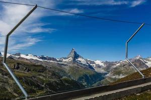 Senderismo en los alpes suizos con campo de flores y el pico Matterhorn al fondo. foto