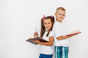 Feliz niña y niño de 7 años sobre fondo blanco. foto