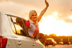 mujer feliz niña va a un viaje de verano en coche. foto