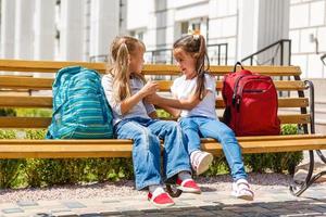 Two cute schoolgirl girls after school. End of school year photo