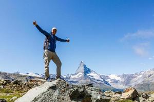 caminante en la cima de un paso contra montañas nevadas en los alpes. suiza, caminata cerca del monte Matterhorn. foto