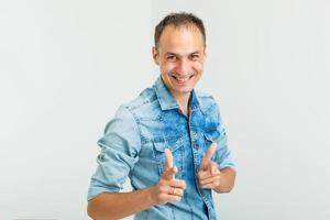 Image of positive guy 30s laughing and pointing fingers at camera like hey you isolated over white background photo